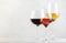 Red, rose and white wine glasses set on gray table background. Wine tasting. Hard light and harsh shadows