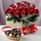 red roses bouquet in a gift box. Valentines day present. Sweet chocolates, ribbon and bow