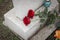 Red roses and candle on old grey tombstone. Funeral ceremony