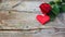 Red roses flowers with red hearts on old wooden background. Romantic Valentines holidays concept. Copy space. Top view