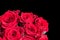 Red roses isolated on black background. Romantic bouquet of flowers.