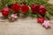 Red roses, mistletoe, fabric stars and moss on wooden background
