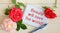 Red roses and a notebook with the inscription Beauty will save the world. Motivation banner