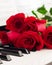 Red roses piano keys romantic background.