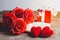 Red roses, red heart, notebook and gift box on a wooden background