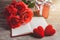 Red roses, red heart, notebook and gift box on a wooden background