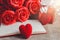 Red roses, red heart, notebook and gift box on a wooden background