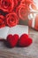 Red roses, red heart, notebook and gift box on a wooden background