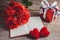 Red roses, red heart, notebook and gift box on a wooden background