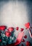 Red roses with ribbon and hearts on gray desktop background, top view. Layout for Valentines day