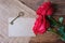 Red roses and vintage heart shape key on wooden floor for Valentine& x27;s concept. Paper note for text