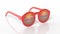 Red round-lens sunglasses with sunset reflection on lens