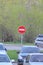 Red round road sign with white stripe prohibiting movement on a city street with cars. Do not enter. concept of