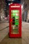 Red royal telephone booth in London city night scene