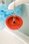 Red rubber bath plug on chain