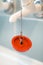 Red rubber bath plug on chain