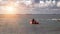 A red rubber coast guard rescue boat with a lifeguard sails to large merchant ships and tankers delivering cargo by sea