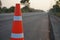 Red rubber cones are placed in the paved road