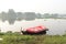 Red rubber inflatable boat, leaning on the lake shore waiting to be rented by the fishermen. in Indonesia