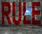 Red RULE word on grey grunge concrete wall