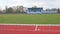 Red running track on athletic stadium in fall. Abandoned athletics track in autumn. Panoramic view on football field