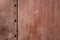 Red rusted metal hull with rivets, background texture