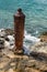 Red Rusty Steel Bollard on the Shoreline of the Caribbean sea an