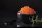 red salmon caviar in a small black bowl