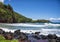 Red sand and chunks lava along the shoreline at Koki Beach on the Island of Maui in the State of Hawaii.