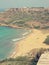 Red sand Ramla beach on Gozo island, Malta, on a sunny day; faded, retro style