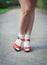 Red sandals with white socks on girl legs in fifties style