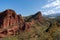 Red sandstone formations rise in the background of a stunning mountainous landscape