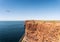 Red sandstone high coast on Helgoland island against blue sea and sky