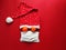Red santa claus hat, tangerines like eyes and medical mask on red background