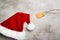 Red santa hat and a gift tag on a gray concrete table