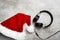 Red santa hat and a headset on a gray concrete table