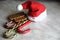 A red Santa hat, three candy canes and a pair of shortbread cookies. Christmas and new year sweets, Christmas dwarf cap.