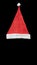 Red santa hat with white bubo and edging on a black background. Top view