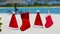 Red Santa hats and Christmas stocking hanging on tropical beach