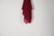 red scarf hung on the wall. Thin fabric texture is commonly used for fashion materials.