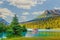 Red sea plane on lake in Moose Pass, Alaska in evening sunshine with mountains in background and surrounded by evergreen trees