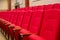 Red seats armchairs in theater in a row. Theater or conference room interior