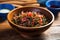 red seaweed salad in a blue rimmed bowl on a wooden table