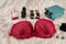 Red seductive bra with perfumes on beige cloth