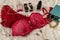 Red seductive bra with perfumes on beige cloth