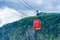 Red Seilbahn cable car gondola against Zwolferhorn mountain