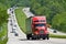 Red Semi Truck Climbing Hill On Interstate Highway
