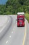 Red Semi Truck on Interstate With Copy Space Vertical