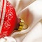 Red shiny christmas toy lies on a white silk cloth.. Christmas decorations and a red ribbon bow isolated on white. Hanging balls,