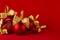 Red shiny different christmas balls with gold shimmer bow on bright deep red background, closeup, copy space. New year background.